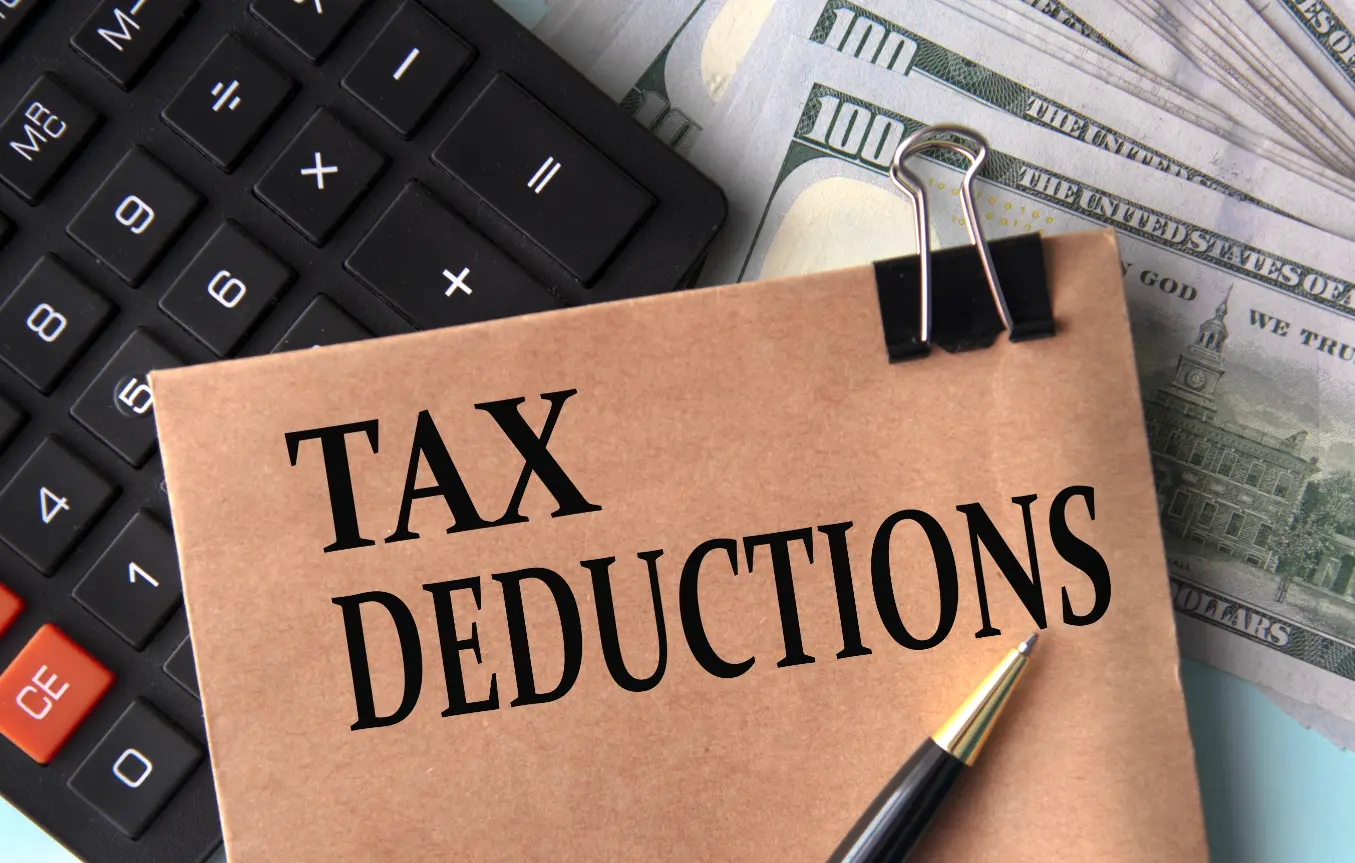 Folder labeled tax deductions with calculator and bills representing tax strategy and financial planning