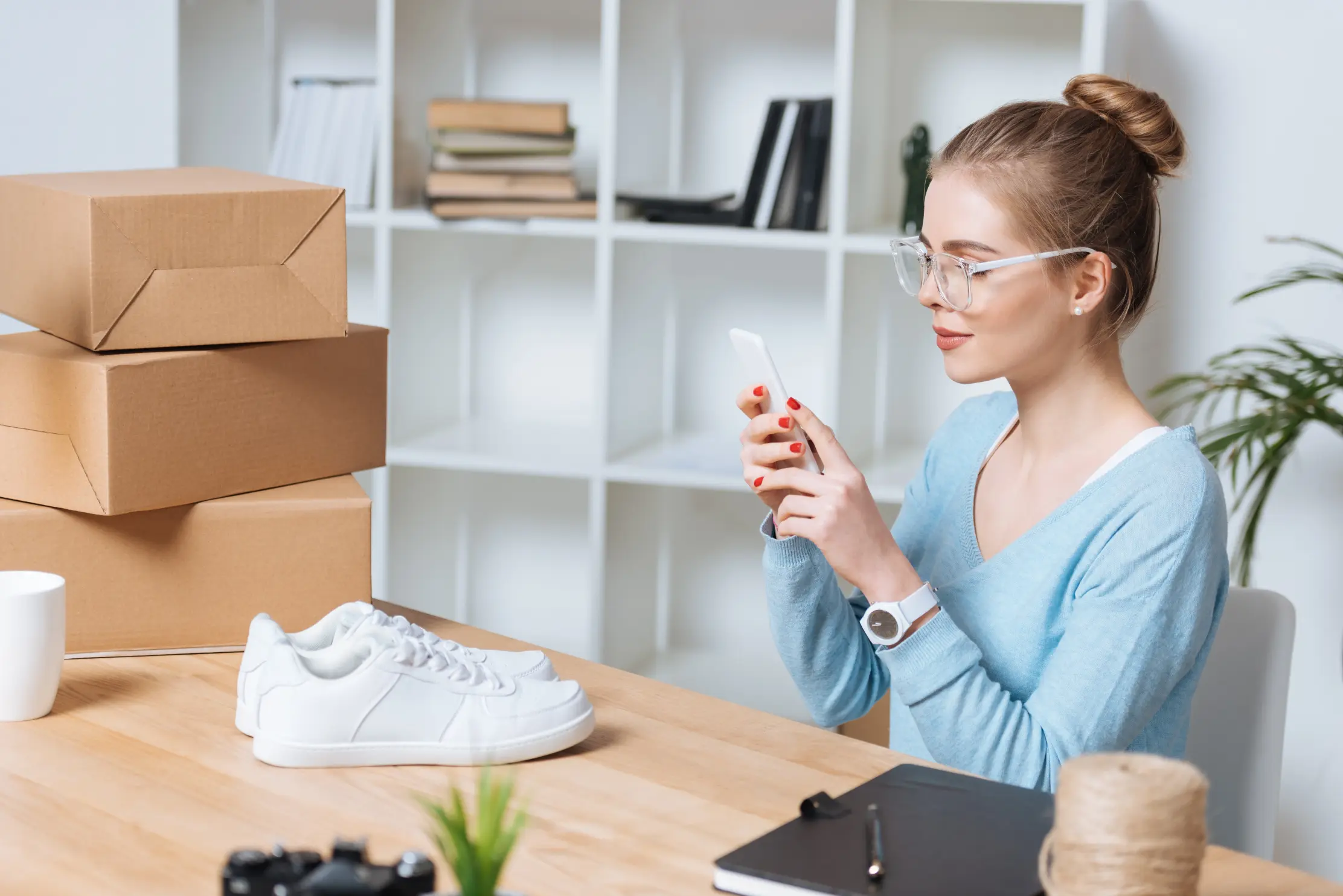 Business professional using her mobile phone at her desk while reviewing growth strategy tasks