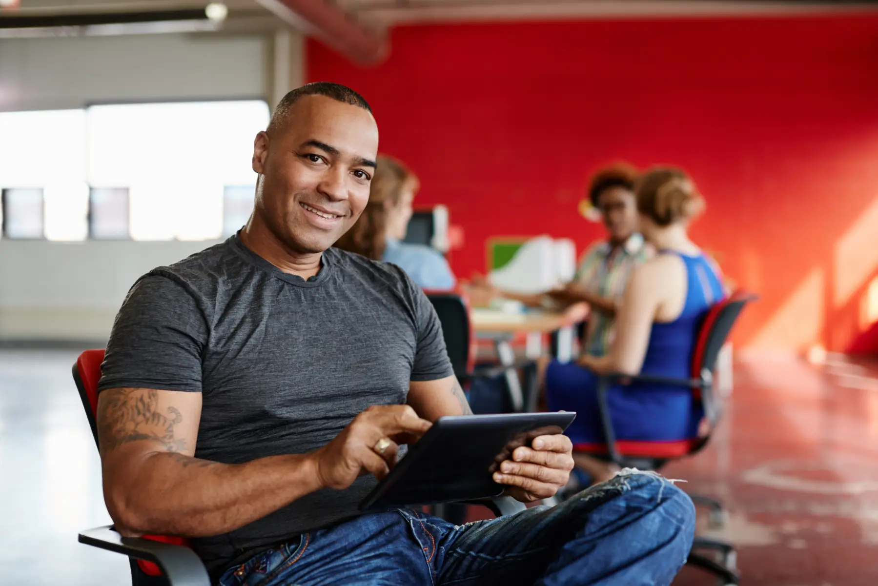 Smiling business owner using a tablet in the office while reviewing financial planning insights