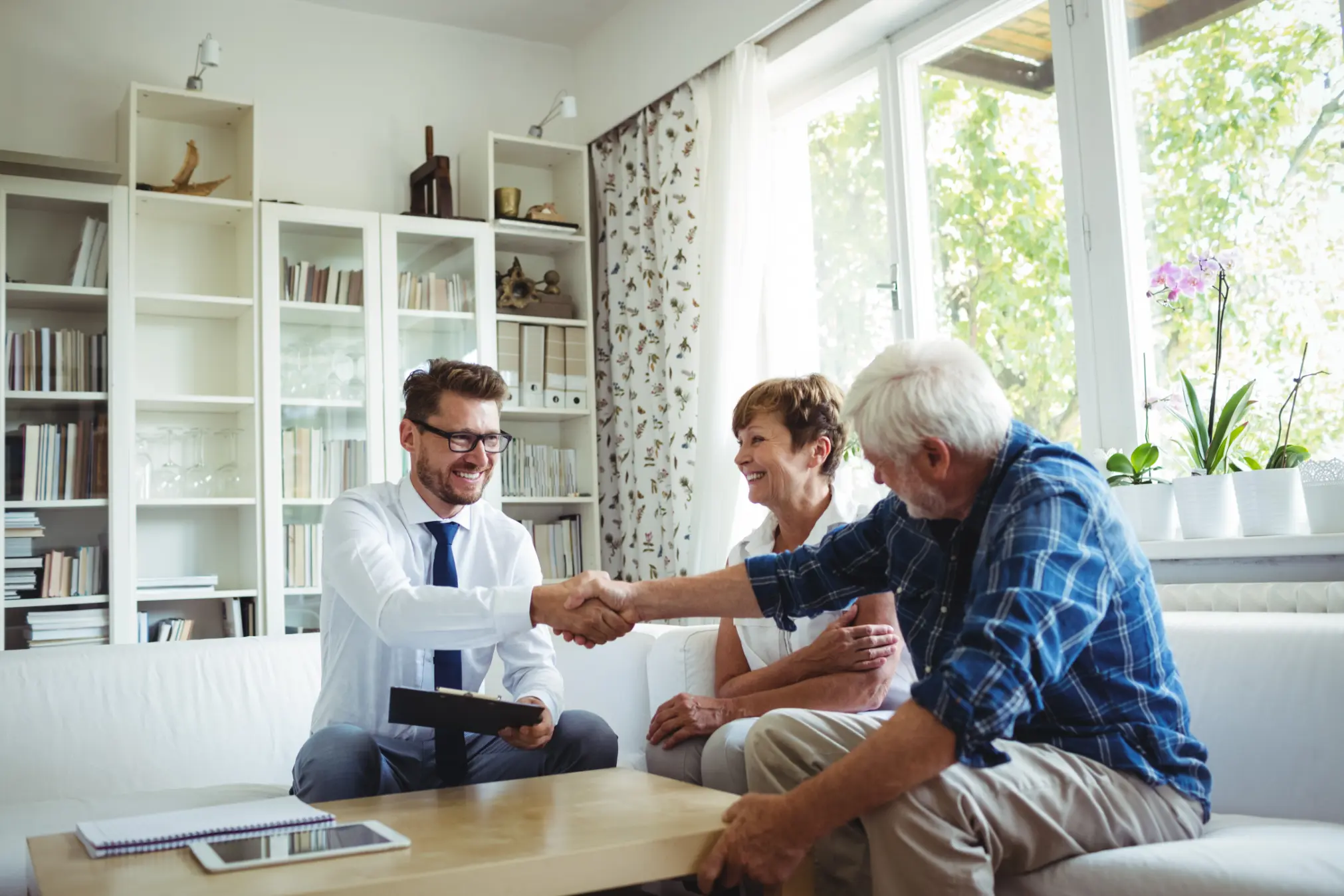 Financial advisor shaking hands with a senior client while discussing retirement planning options