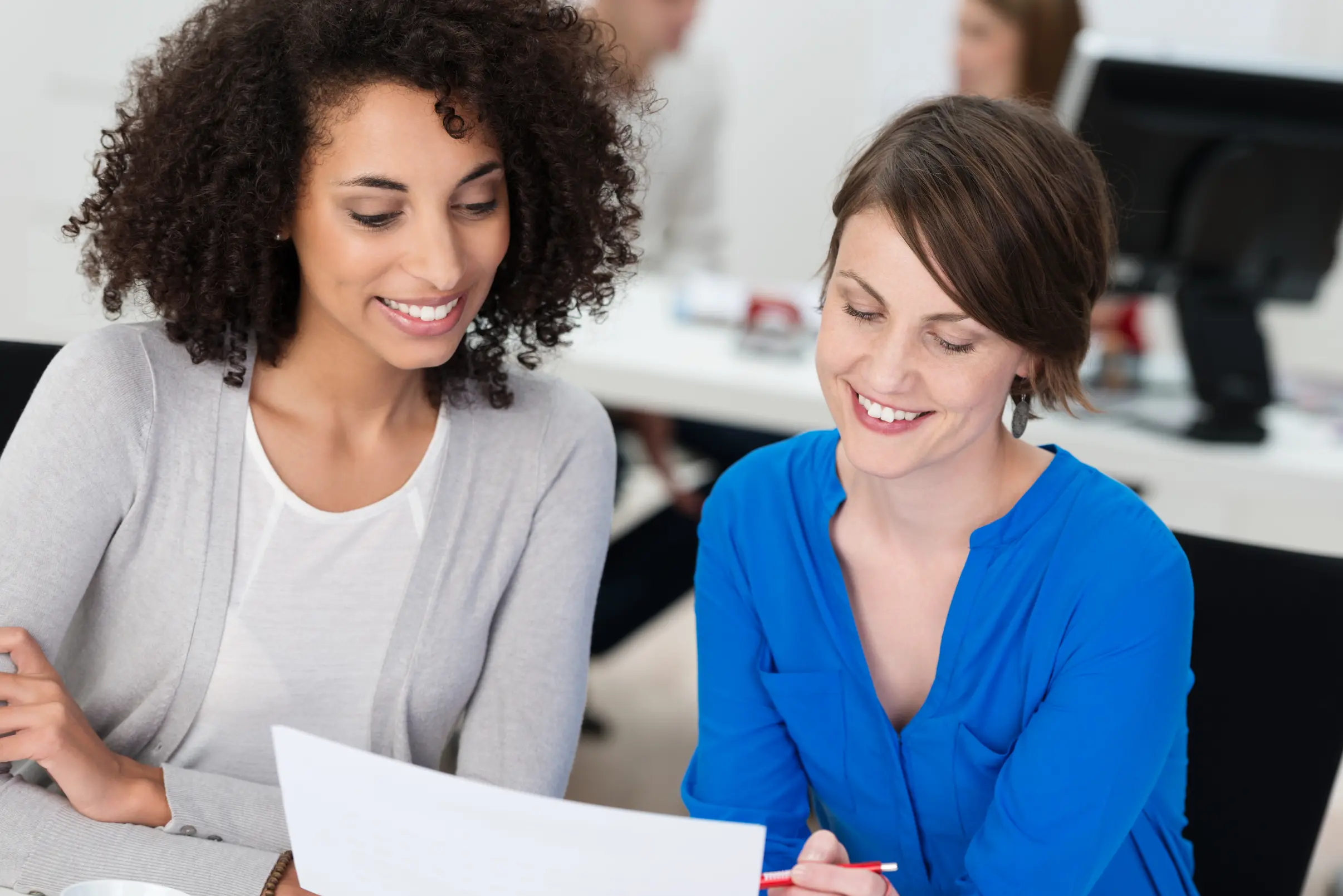 Two women reviewing a financial document for business management in Colorado