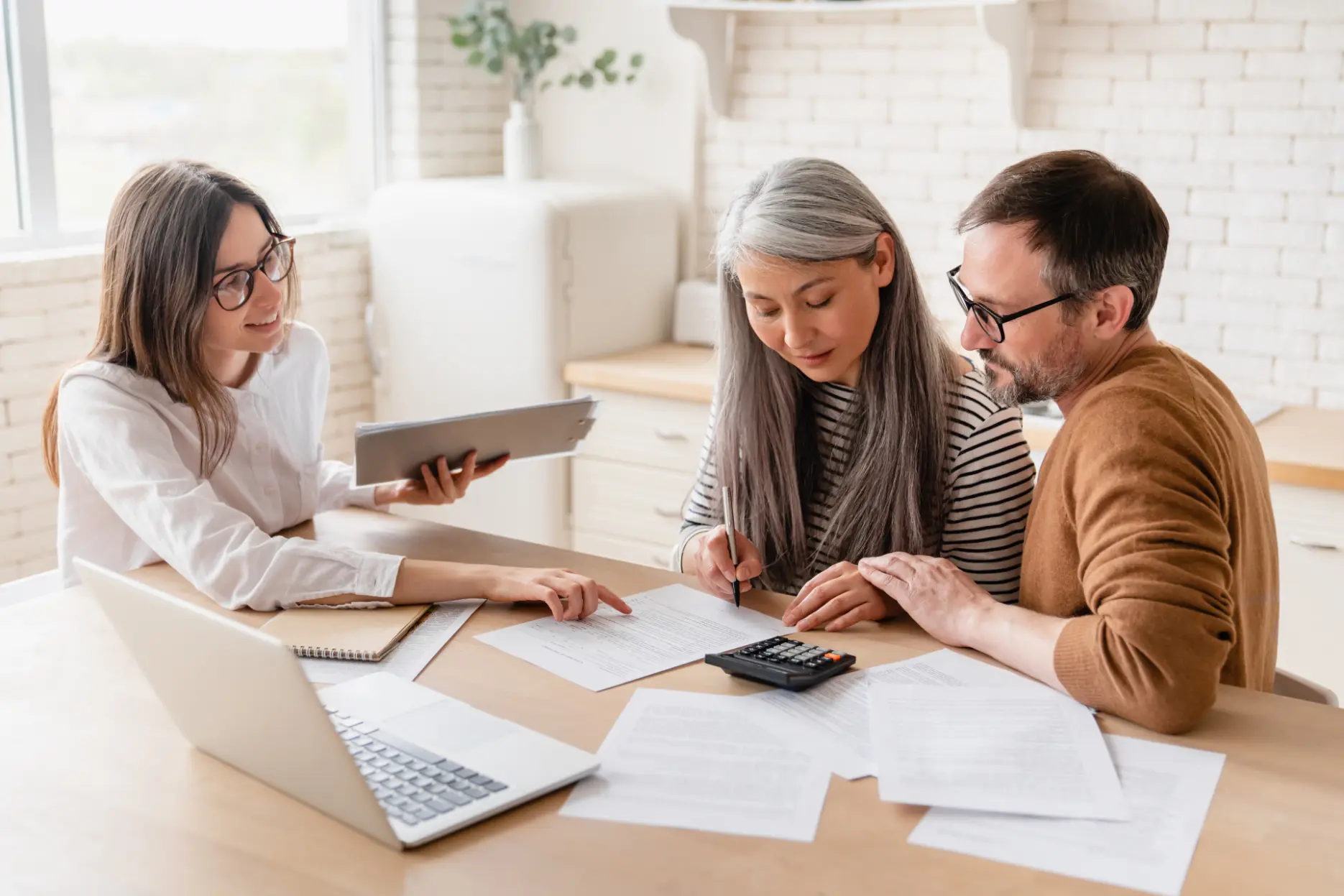 Senior clients reviewing and signing documents with a financial advisor for legacy planning