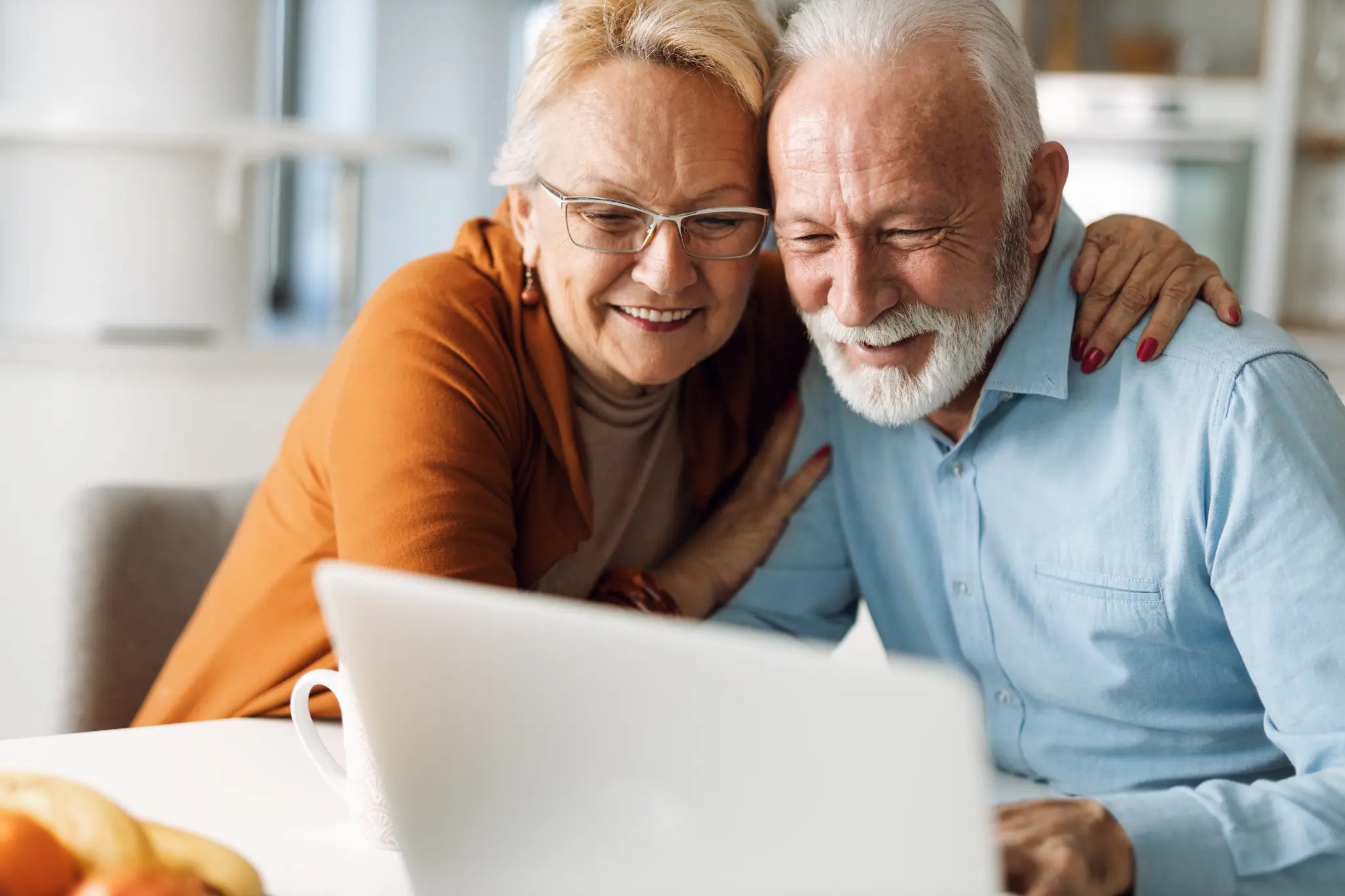 Senior clients reviewing business exit strategy plans on a laptop with confidence