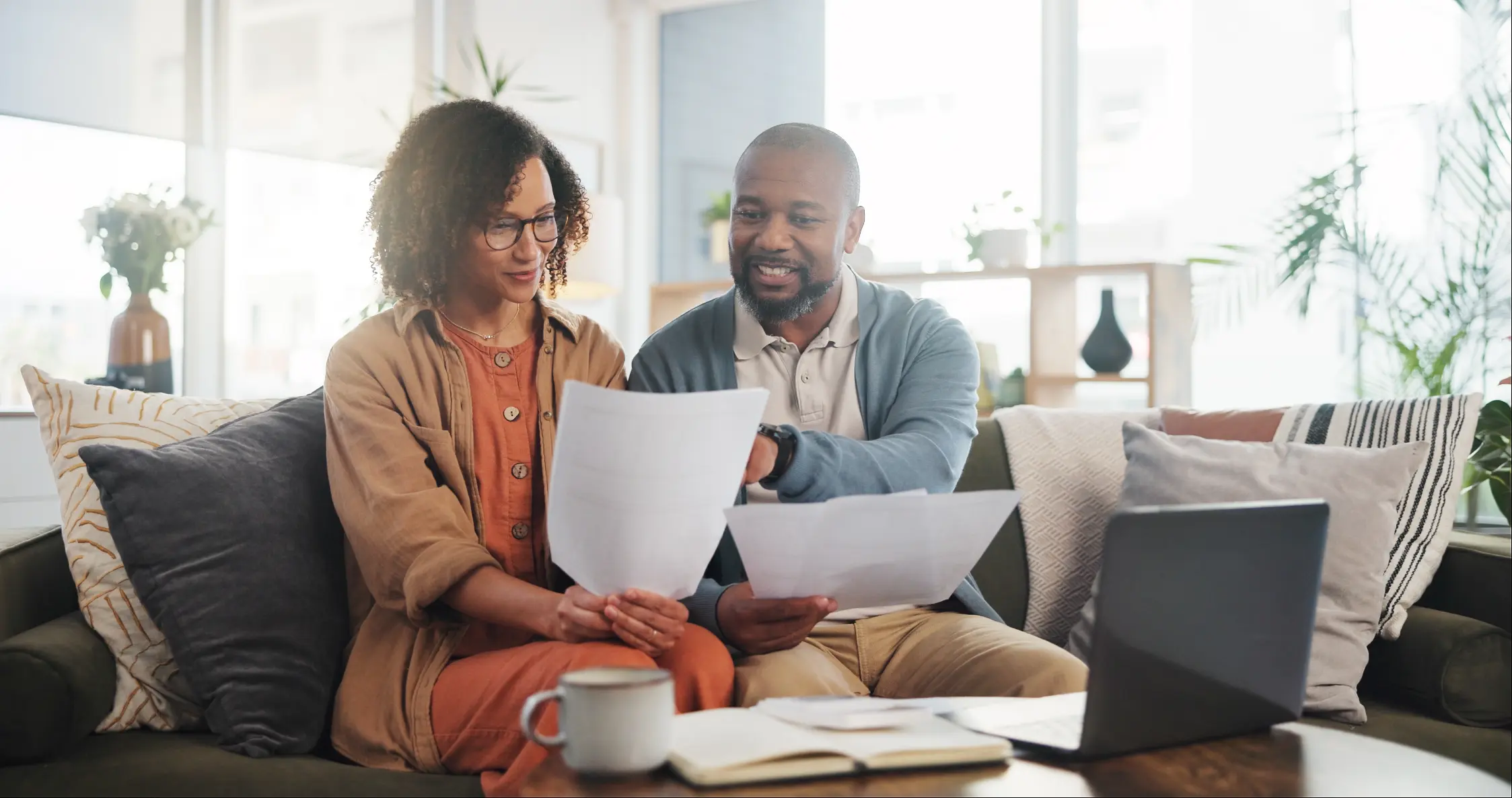 Couple reviewing financial documents together at home while planning wealth preservation strategies